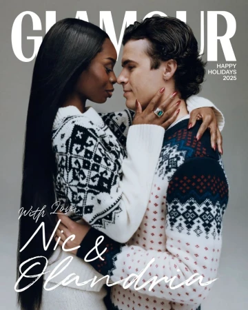Magazine cover featuring a couple in holiday sweaters embracing in front of a gray backdrop. The cover includes the magazine's title.