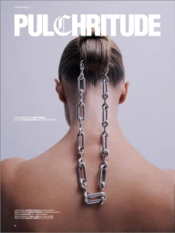 Model Lou Schoof seen from behind with a sleek high bun and a chunky silver chain hanging down her bare back.