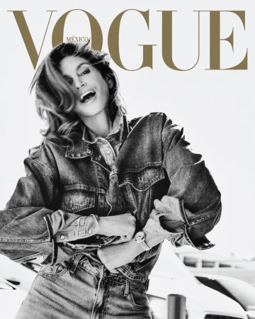 Vogue Mexico cover featuring a cheerful woman in a denim jacket and jeans, her mouth open in a smile, and white architectural background.