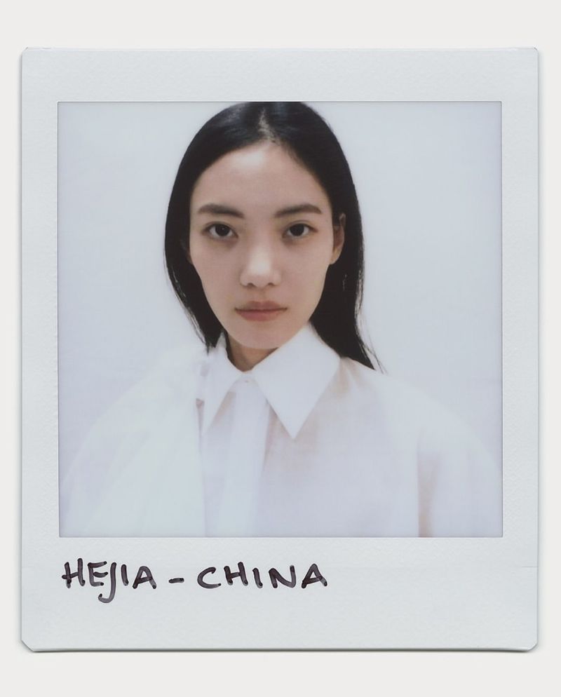 Close-up shot of an Asian woman in a white shirt, photographed in a Polaroid style with 'HEJIA - CHINA' handwritten below the image.