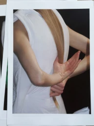 Model in white top holding hair behind back in Issey Miyake x Byredo editorial
