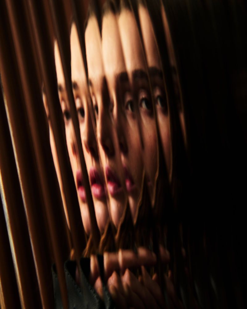 Close-up studio portrait of an adult woman with a blurred, layered effect creating a distorted, multi-exposure style with dark background.