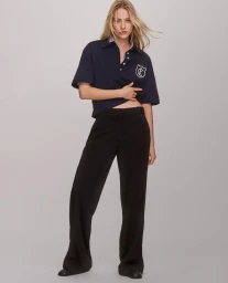 Model in navy polo shirt and dark trousers against a neutral background for Calvin Klein SP25