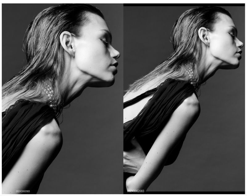 Monochrome portrait of model Daphne Maas wearing a dark dress and pearl necklace against a grey backdrop