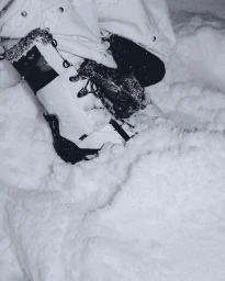 Close-up shot of white snow boots standing in deep fresh snow during winter.