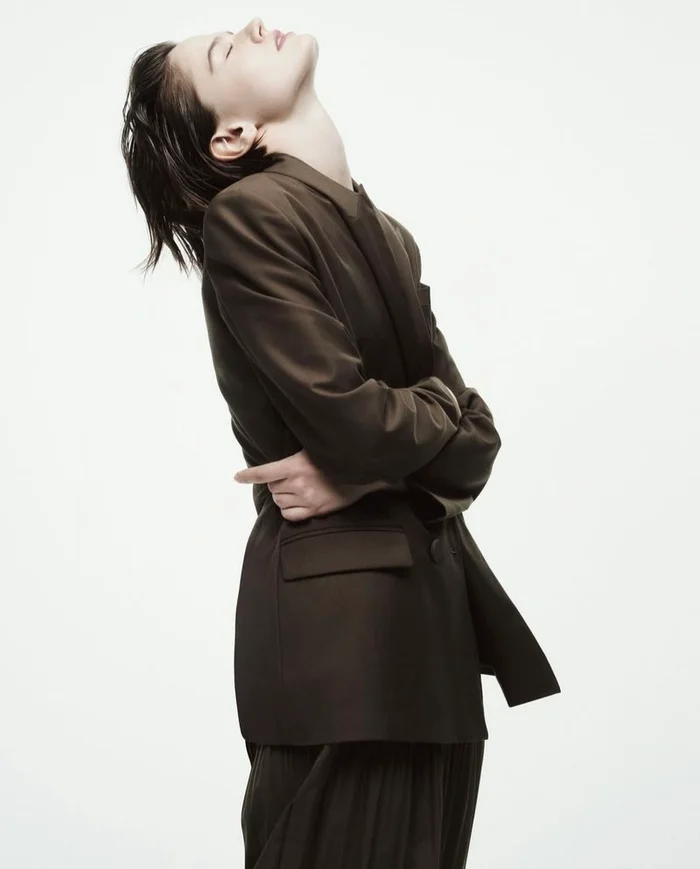 Model in brown blazer with head tilted back against white background for Armani Exchange campaign