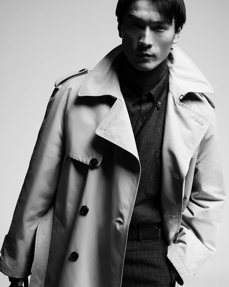 Man wearing a belted trench coat and dark turtleneck against a plain background for Tod's men's collection.