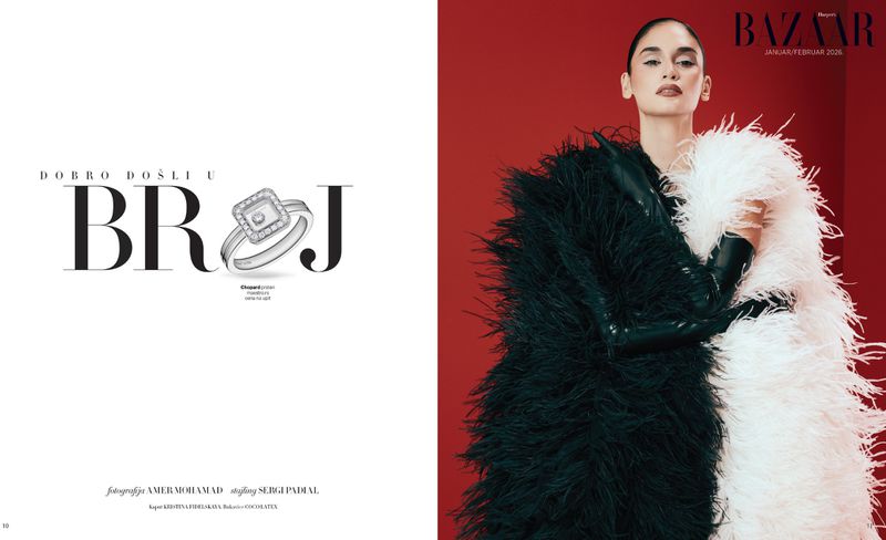 Editorial fashion shot: adult woman poses in black and white feather boa against a red background in Bazaar magazine editorial.