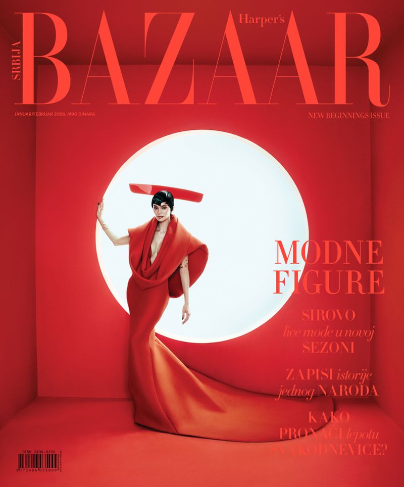 Harper's Bazaar cover featuring a woman in a red gown and headpiece, posing in a red studio with a circular white backdrop.