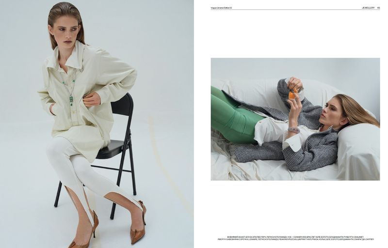 Editorial fashion shot of a woman in a long white shirt sitting on a chair; a second woman lies on a couch with a jacket and leggings.