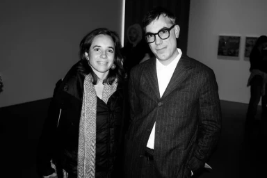 Black and white portrait of a woman and man standing together in an art gallery setting
