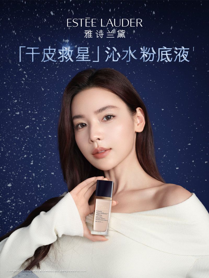 Portrait of an Asian woman posing with Estee Lauder foundation, featuring makeup, a white sweater, and a blue, starry background.