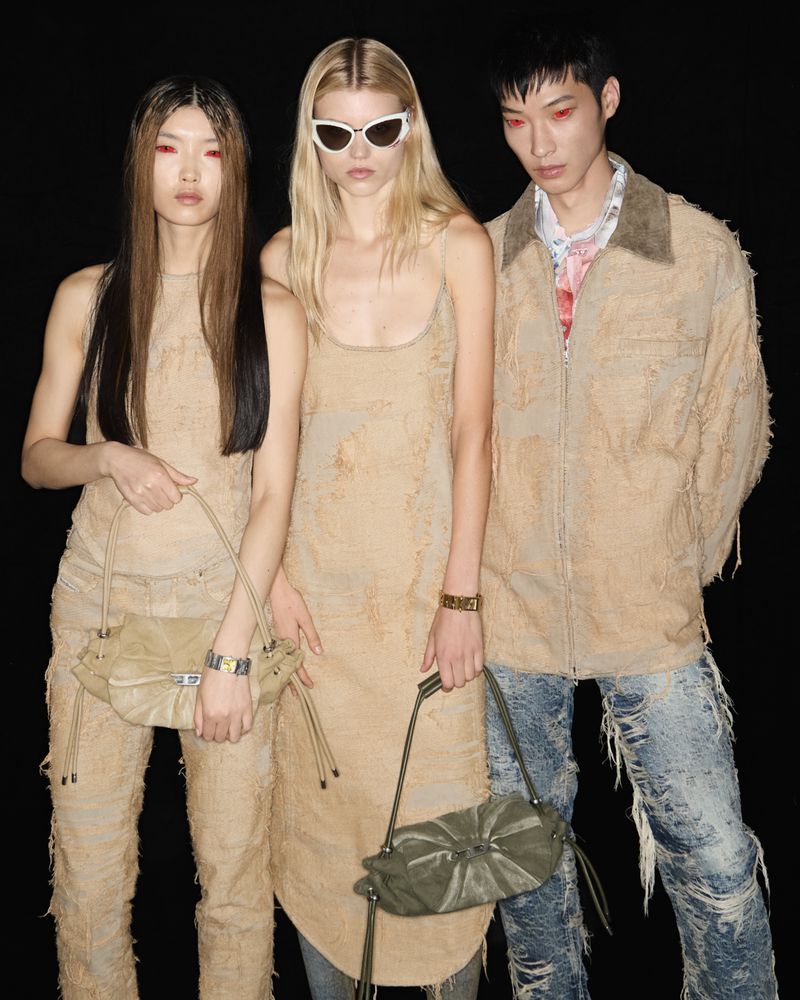 Three fashion models pose in coordinated beige outfits and sunglasses, each holding a handbag, against a dark studio backdrop.