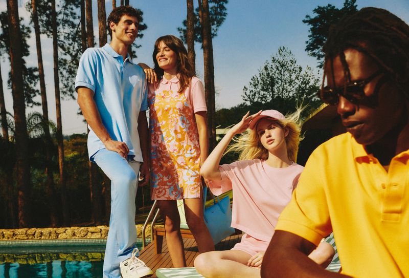 Group of diverse young adults in casual summer fashion, posing near a pool with tall trees in background, bathed in soft, natural light.