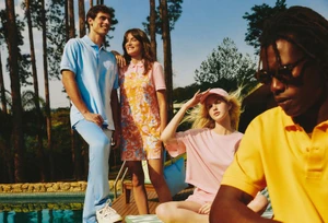 Four models in colourful casual apparel relaxing outdoors by a pool surrounded by trees for the Lacoste Brazil Summer Pack 2024 campaign.