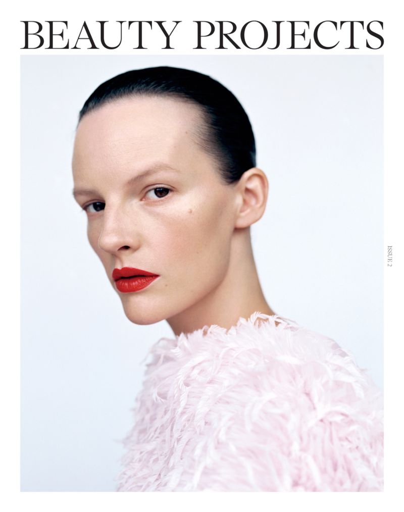 Beauty projects cover featuring a woman with red lipstick and a textured top against a white background in a close-up portrait.
