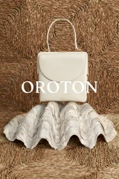 A white handbag resting on a large seashell against a woven straw background with overlaid text reading Oroton.