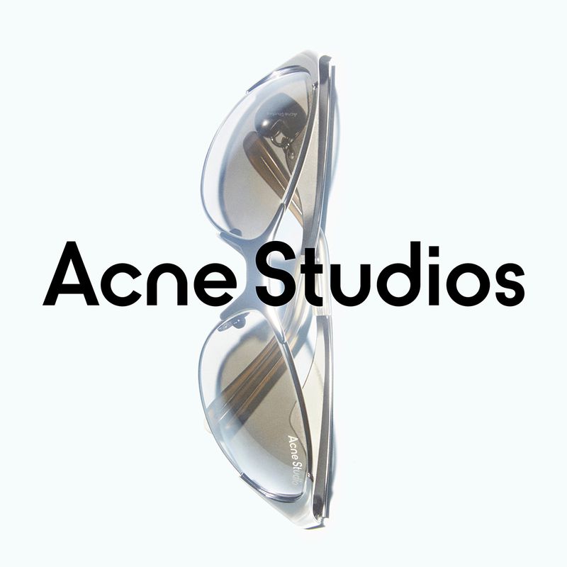 Close-up of transparent gray sunglasses from Acne Studios, displayed on a white background, with the brand name printed on the image.