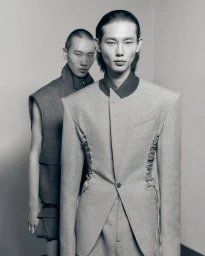 Two male models in structured tailored garments posing in a minimal studio setting for Mugler Spring Summer 2025