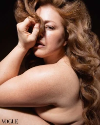 Close-up portrait of a woman holding a lock of long brown hair across her face for Vogue Philippines by Alina Gross