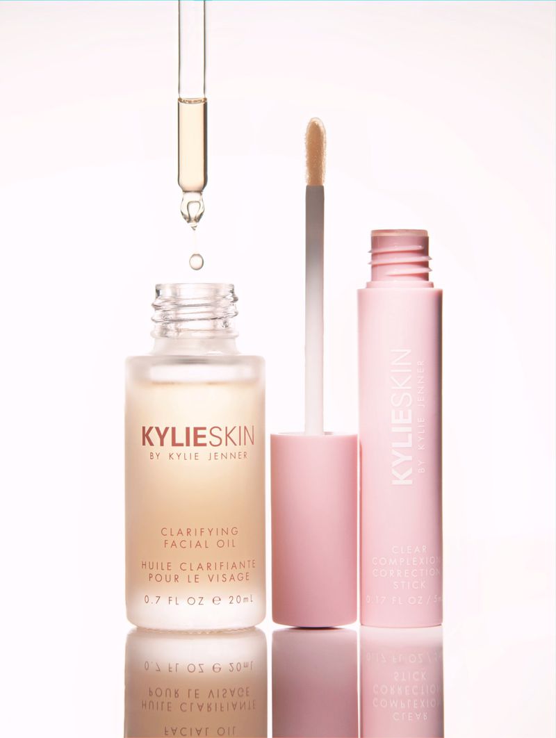KylieSkin facial oil product with dropper and pink container on a reflective surface against a white backdrop in a studio setting.