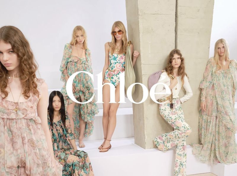 Fashion editorial shot featuring six female models wearing floral print clothing, with the Chloe brand name as a large graphic overlay.