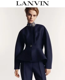 Model wearing dark navy peplum jacket with jewelled collar against a white background for Lanvin Winter 2024
