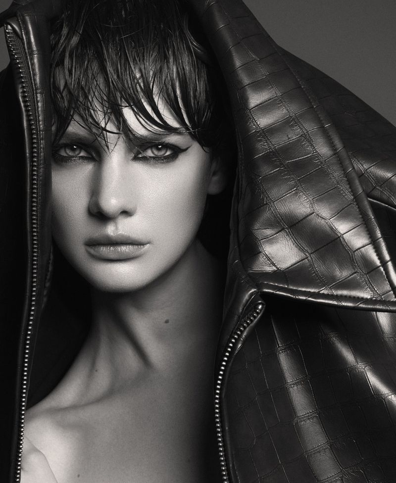 Close-up portrait of a woman with wet hair wearing a textured leather jacket pulled up over her head, shot in monochrome.