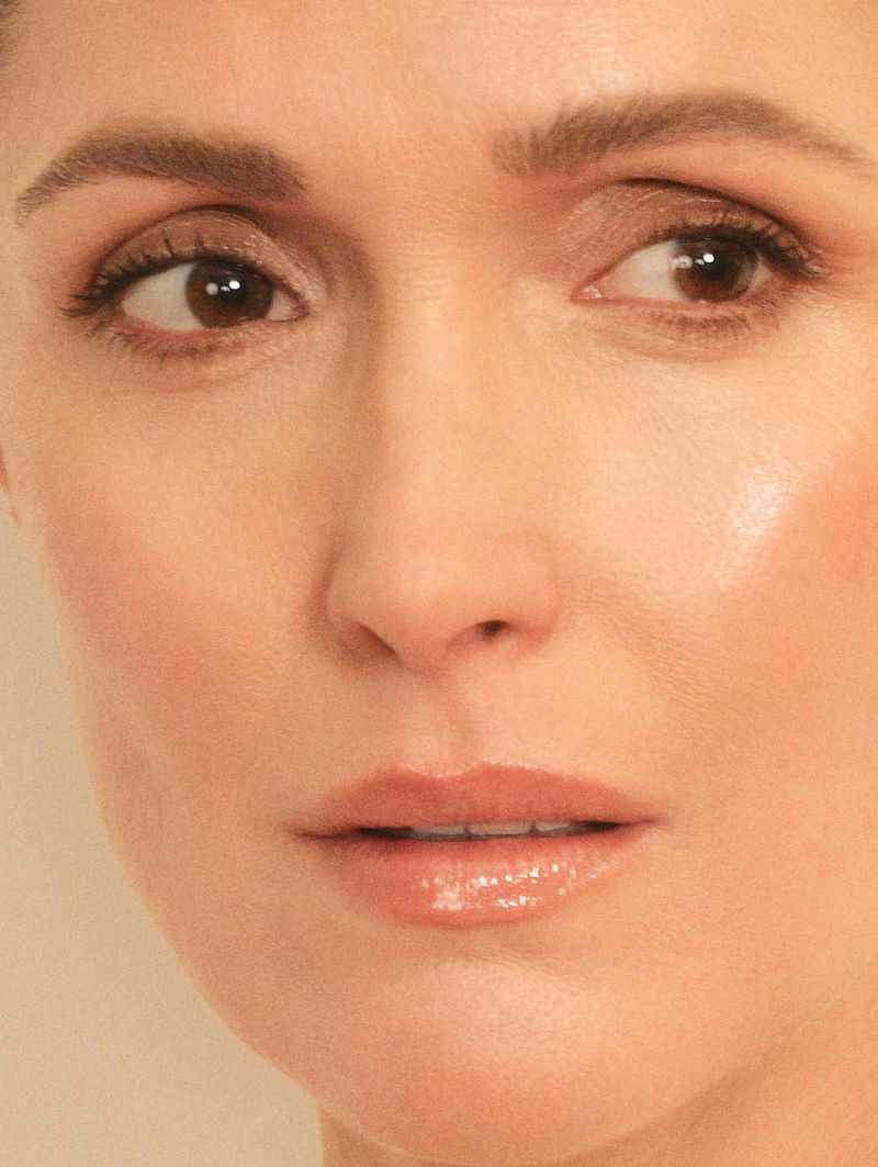 Close-up portrait of an adult woman with fair skin, brown eyes, light brown hair, wearing nude lipstick, and looking to the side.