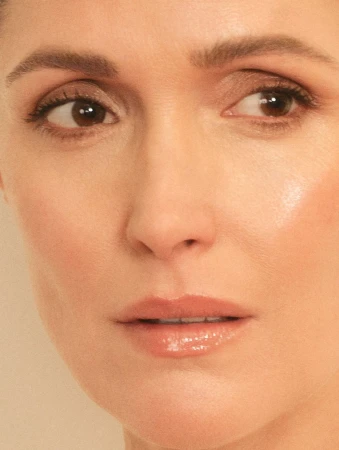 Close-up portrait of an adult woman with fair skin, brown eyes, light brown hair, wearing nude lipstick, and looking to the side.