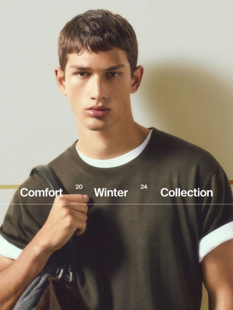Portrait of a young adult male model wearing a T-shirt and carrying a shoulder bag, with text overlay promoting a winter collection.