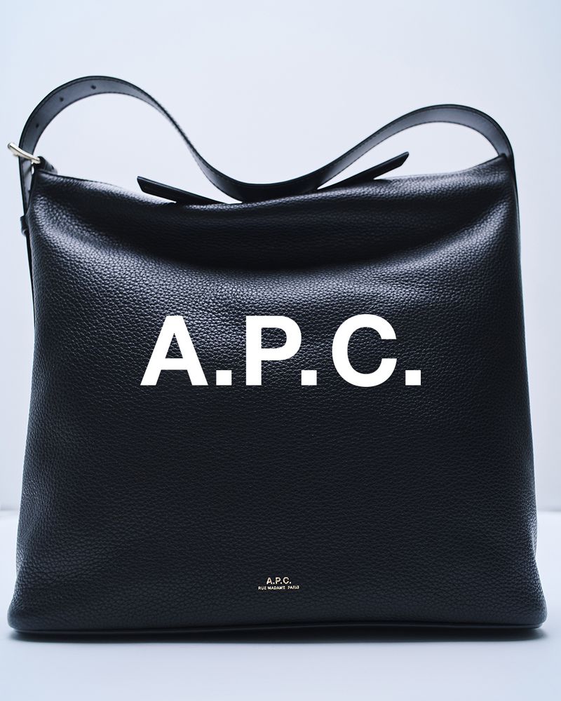 Close-up of a black leather A.P.C. shoulder bag with a short strap against a white background, showcasing fashion accessory.