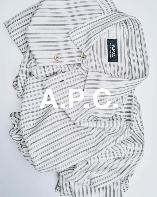 Striped collared shirt by A.P.C. is captured in a flat lay with a bright background, featuring the brand's logo prominently.