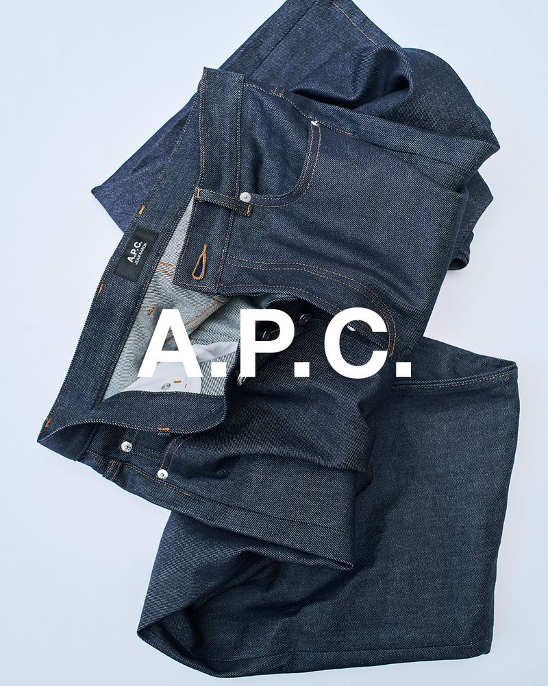 A.P.C. brand blue denim jeans are displayed on a white background in a studio-style setup, capturing their texture and design.