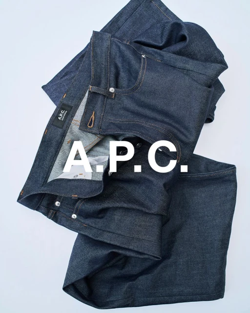 A.P.C. brand blue denim jeans are displayed on a white background in a studio-style setup, capturing their texture and design.