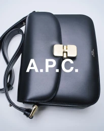Black leather shoulder bag with gold hardware against a clean white background featuring A.P.C. branding