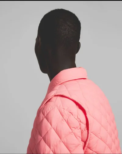 Model from behind wearing a pink quilted vest against a light grey background for K-Way R&D S/S 24