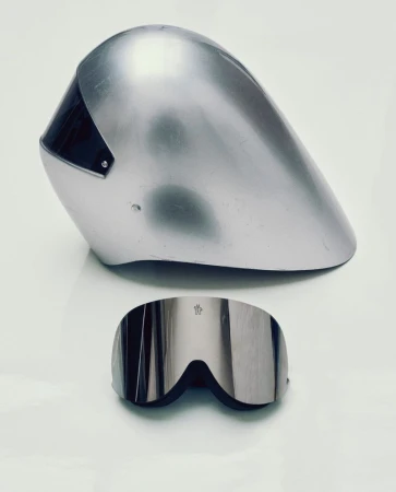 Silver ski helmet and reflective goggles sit on a white surface, capturing a sleek and futuristic aesthetic for winter sports.