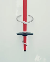 Diamond pave open cuff bracelet and wrap ring styled around a red ski pole against a clean white backdrop.