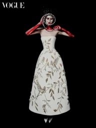 Model in strapless white gown with gold embroidery wearing a snake headdress against a black seamless background for Vogue Portugal.