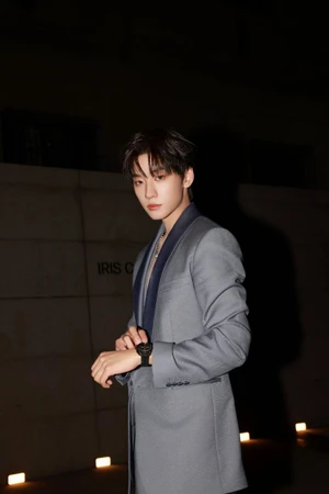 Yu JingTian wearing a grey blazer adjustment his watch outdoors at night for Dior, photographed by Anne Zheng Chen.
