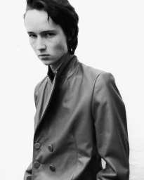 Monochrome portrait of a model wearing a structured jacket against a plain light background for Aaron Esh A/W 24
