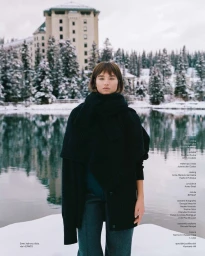 Model Meghan Roche wearing a black sweater and scarf outdoors in a snowy mountain landscape for Vogue Czechoslovakia Horalka project