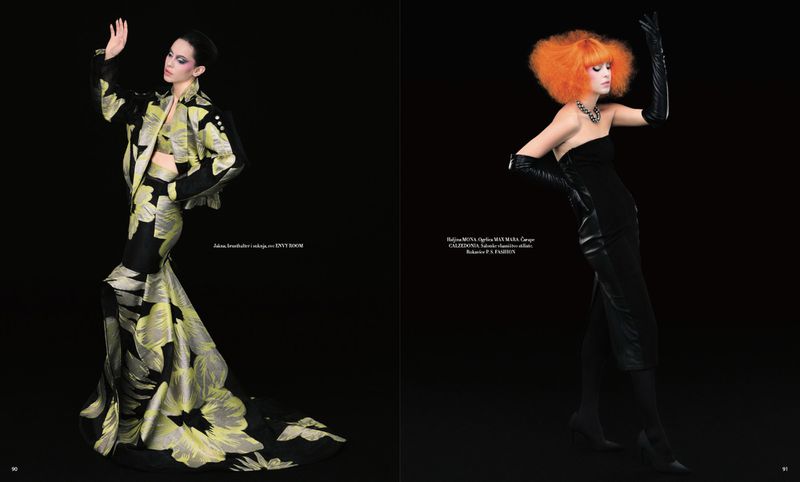 Two models strike poses in black and yellow gowns in a studio fashion editorial against a solid black backdrop with runway couture.