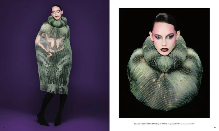 Fashion editorial shot of a woman in a green and grey dress with a large ruffled collar on a purple background in a studio.