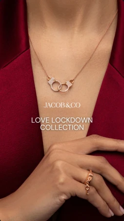 Necklace and ring jewellery from Jacob & Co's Love Lockdown Collection, worn with a red shirt, accessorising the hands and neck.