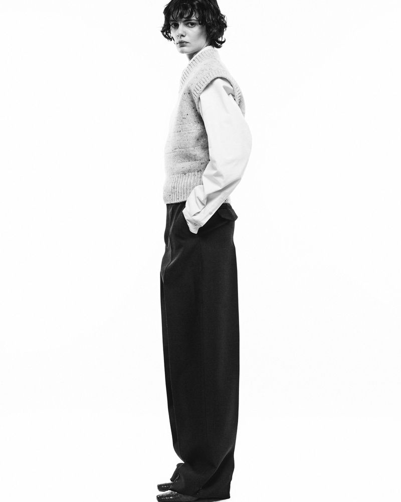 Model in layered knit vest and trousers against a clean white background for Tod's FW2024 campaign