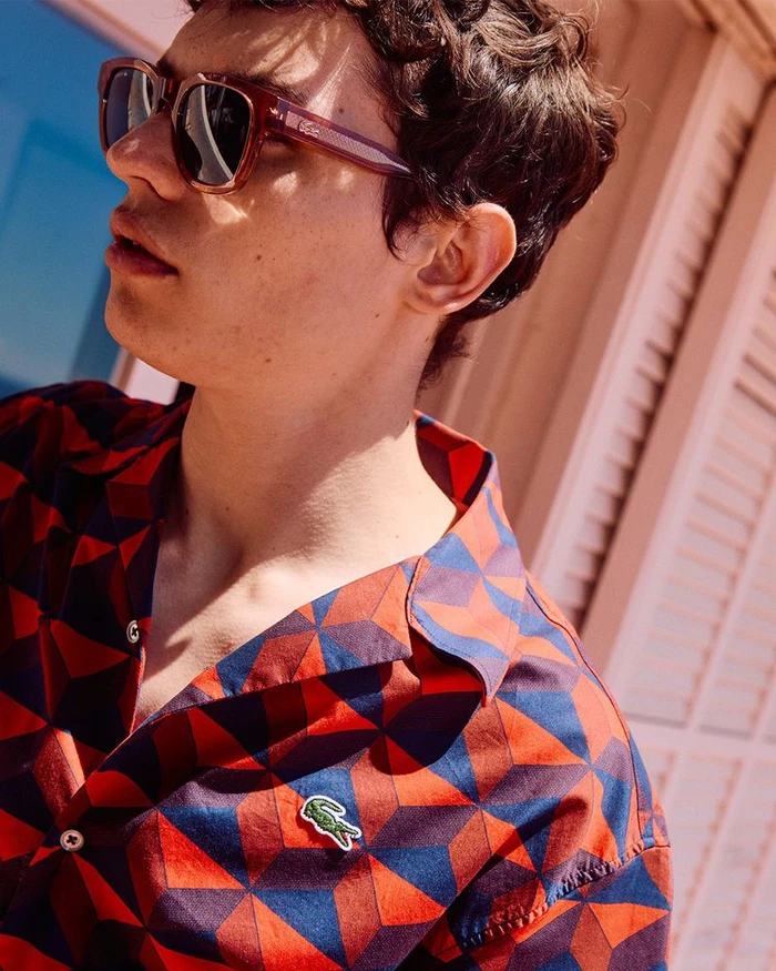 Close-up portrait of a man wearing geometric print shirt and sunglasses for Lacoste Summer Pack