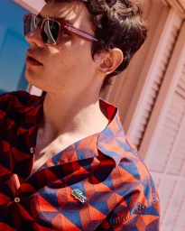 Close-up portrait of a man wearing geometric print shirt and sunglasses for Lacoste Summer Pack