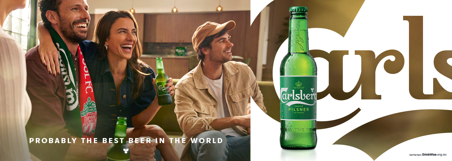 A group of friends celebrates with beer while watching sports. A bottle of beer is featured prominently against a tan background.